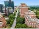Wide aerial shot featuring a brick apartment building near a tree-lined street, blending city and residential living at 1325 Peachtree Ne St # 401, Atlanta, GA 30309