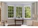 Bright bay window with green tree views, console table, and flowers at 1325 Peachtree Ne St # 401, Atlanta, GA 30309