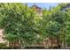 Charming brick apartment building partially concealed by lush trees, blending urban living with natural beauty at 1325 Peachtree Ne St # 401, Atlanta, GA 30309