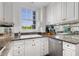 Well-lit kitchen featuring granite countertops, stainless steel appliances, and white cabinets at 1325 Peachtree Ne St # 401, Atlanta, GA 30309