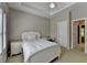 Well-lit bedroom with a white bed, desk, and ceiling fan at 1875 Briergate Dr, Duluth, GA 30097