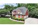 Traditional two-story brick home with manicured landscaping, three-car garage and extended driveway at 1875 Briergate Dr, Duluth, GA 30097