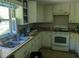 Cozy kitchen features a double sink, white cabinets, and all white appliances at 2291 Piney Grove Rd, Loganville, GA 30052