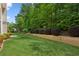 Beautiful backyard with green grass and retaining wall with bushes, providing privacy at 4114 Suwanee Trail Dr, Buford, GA 30518