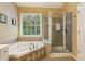 Modern bathroom with a separate glass-enclosed shower, and a soaking tub with stylish tile work at 4114 Suwanee Trail Dr, Buford, GA 30518