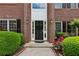 Close-up of the front door with sidelights, brick surround and colorful flower beds enhancing curb appeal at 4114 Suwanee Trail Dr, Buford, GA 30518