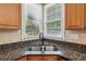 Kitchen sink with granite countertops, tile backsplash and window view at 4114 Suwanee Trail Dr, Buford, GA 30518