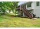 A backyard with a wooden deck, stairs, green grass, and mature trees at 6397 Autumn View Nw Trce, Acworth, GA 30101