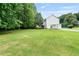 A spacious backyard with green grass, trees, and a mobile storage container at 6397 Autumn View Nw Trce, Acworth, GA 30101
