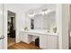Bright bathroom features a double vanity with plentiful lighting and wood flooring at 6397 Autumn View Nw Trce, Acworth, GA 30101