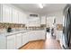 Galley kitchen featuring white cabinetry, stainless steel appliances, and wood-look flooring at 6397 Autumn View Nw Trce, Acworth, GA 30101