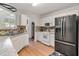 Galley kitchen featuring white cabinetry, stainless steel appliances, and wood-look flooring at 6397 Autumn View Nw Trce, Acworth, GA 30101