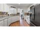 Galley kitchen featuring white cabinetry, stainless steel appliances, and wood-look flooring at 6397 Autumn View Nw Trce, Acworth, GA 30101