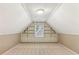 Large attic space with white trim, built-in shelving, a window, and neutral carpeting at 769 Hampton Sw Pl, Marietta, GA 30064