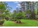 Large green backyard with mature trees, landscaping, and partial view of the home's exterior at 769 Hampton Sw Pl, Marietta, GA 30064