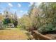 Backyard with a winding creek, lush greenery, and a view of the house and shed at 769 Hampton Sw Pl, Marietta, GA 30064