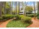 The meticulously landscaped backyard with brick walkways, lush greenery, and a view of the home's back porch at 769 Hampton Sw Pl, Marietta, GA 30064