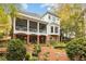 Two-story home featuring a covered back porch overlooking a manicured backyard with mature landscaping and pond at 769 Hampton Sw Pl, Marietta, GA 30064