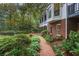 Landscaped backyard with a brick walkway that leads to a two-story home with a porch at 769 Hampton Sw Pl, Marietta, GA 30064