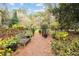A wooden bench sits by a gated path in a lush garden setting with mature trees at 769 Hampton Sw Pl, Marietta, GA 30064