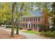 Charming brick two-story home with black shutters, mature landscaping, and a circular driveway surrounded by colorful trees at 769 Hampton Sw Pl, Marietta, GA 30064