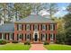 Charming red brick two-story home with black shutters and a manicured front lawn and brick walkway at 769 Hampton Sw Pl, Marietta, GA 30064