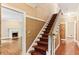 Traditional home hallway with carpeted stairs, hardwood floors, and textured wallpaper accent at 769 Hampton Sw Pl, Marietta, GA 30064