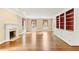 Bright living room featuring hardwood floors, a fireplace, built-in shelving, and a wall of windows at 769 Hampton Sw Pl, Marietta, GA 30064
