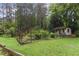 Side view of a garden with an outbuilding surrounded by lots of mature trees and greenery at 769 Hampton Sw Pl, Marietta, GA 30064
