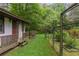 Small outbuilding with a porch and adjacent garden area with a fence and lots of greenery at 769 Hampton Sw Pl, Marietta, GA 30064