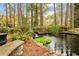 Secluded backyard pond with small stone waterfall, lush vegetation, and peaceful bench at 769 Hampton Sw Pl, Marietta, GA 30064