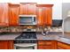 Kitchen features stainless steel appliances, wood cabinets, tile backsplash, and granite countertops at 104 Highlands Ridge Se # 1, Smyrna, GA 30082