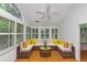 Bright sunroom with white walls, hardwood floors, ceiling fan and multiple windows with white shutters, and comfortable cushioned seating at 104 Highlands Ridge Se # 1, Smyrna, GA 30082