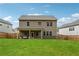 Large backyard view features a covered patio, spacious lawn, and a privacy fence at 2091 Landsburg Way, Lawrenceville, GA 30043