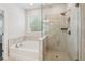 Modern bathroom featuring separate shower with glass door, and soaking tub next to a window at 2091 Landsburg Way, Lawrenceville, GA 30043