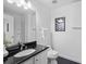 Bathroom features a modern sink with black granite countertop, large mirror and white cabinetry at 800 Peachtree Ne St # 8509, Atlanta, GA 30308