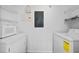 Bright laundry room with white appliances, wire shelving, and an electrical panel for convenience at 800 Peachtree Ne St # 8509, Atlanta, GA 30308