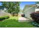 A sunny backyard features a green lawn, wood fence, stone patio, and home with light-green siding at 1283 Mercer Ave, East Point, GA 30344