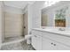 A bright bathroom featuring dual sinks, granite countertops, and a beautiful tiled shower with updated fixtures at 1283 Mercer Ave, East Point, GA 30344