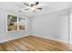 This bedroom features a ceiling fan, a window letting in natural light, and beautiful wood-look flooring at 1283 Mercer Ave, East Point, GA 30344