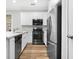 Modern kitchen boasting stainless steel appliances, white cabinets, quartz countertops, and hard wood flooring at 1283 Mercer Ave, East Point, GA 30344