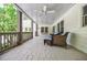 Inviting covered porch features cozy seating, swing, and ceiling fan for ultimate relaxation at 1550 Masters Club Dr, Sandy Springs, GA 30350