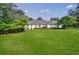 Beautifully landscaped front yard and lawn, with a charming white brick home nestled among mature trees at 1550 Masters Club Dr, Sandy Springs, GA 30350
