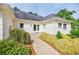 Landscaped entrance to a bright home featuring a brick exterior, manicured bushes, and a paved walkway at 1550 Masters Club Dr, Sandy Springs, GA 30350