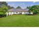 Charming one story home with manicured lawn, lush landscaping, and painted brick exterior at 1550 Masters Club Dr, Sandy Springs, GA 30350
