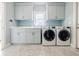 Laundry room featuring a front loading washer/dryer set, plenty of counter space, and light blue cabinetry at 1550 Masters Club Dr, Sandy Springs, GA 30350