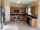 Bright kitchen with stainless steel appliances, tile flooring, and plentiful wood cabinets at 1963 Lakeshore Overlook Nw Cir, Kennesaw, GA 30152