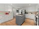 Open kitchen featuring white cabinets, stainless appliances, a center island with cooktop, and hardwood floors at 2871 Liberty Ct, Marietta, GA 30066