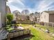 Well-maintained backyard features a patio with seating, fire pit, and garden beds with a fence and a view of neighborhood houses at 510 Rosedown Way, Alpharetta, GA 30022