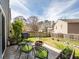 Landscaped backyard featuring a patio area with seating, a fire pit, grill, and a lush lawn, perfect for outdoor entertaining at 510 Rosedown Way, Alpharetta, GA 30022
